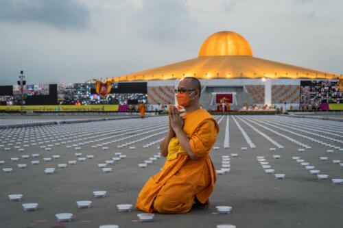 A monk prays while preparing LED lanterns during the Earth Day 2022 celebration at Wat Phra Dhammakaya Temple. Photographer: Matt Hunt / Neato