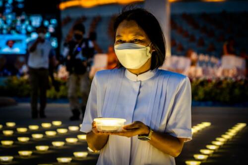 A devotee lights an LED lantern and prays a part of the Earth Day 2022 celebration at Wat Phra Dhammakaya Temple. Photographer: Matt Hunt / Neato